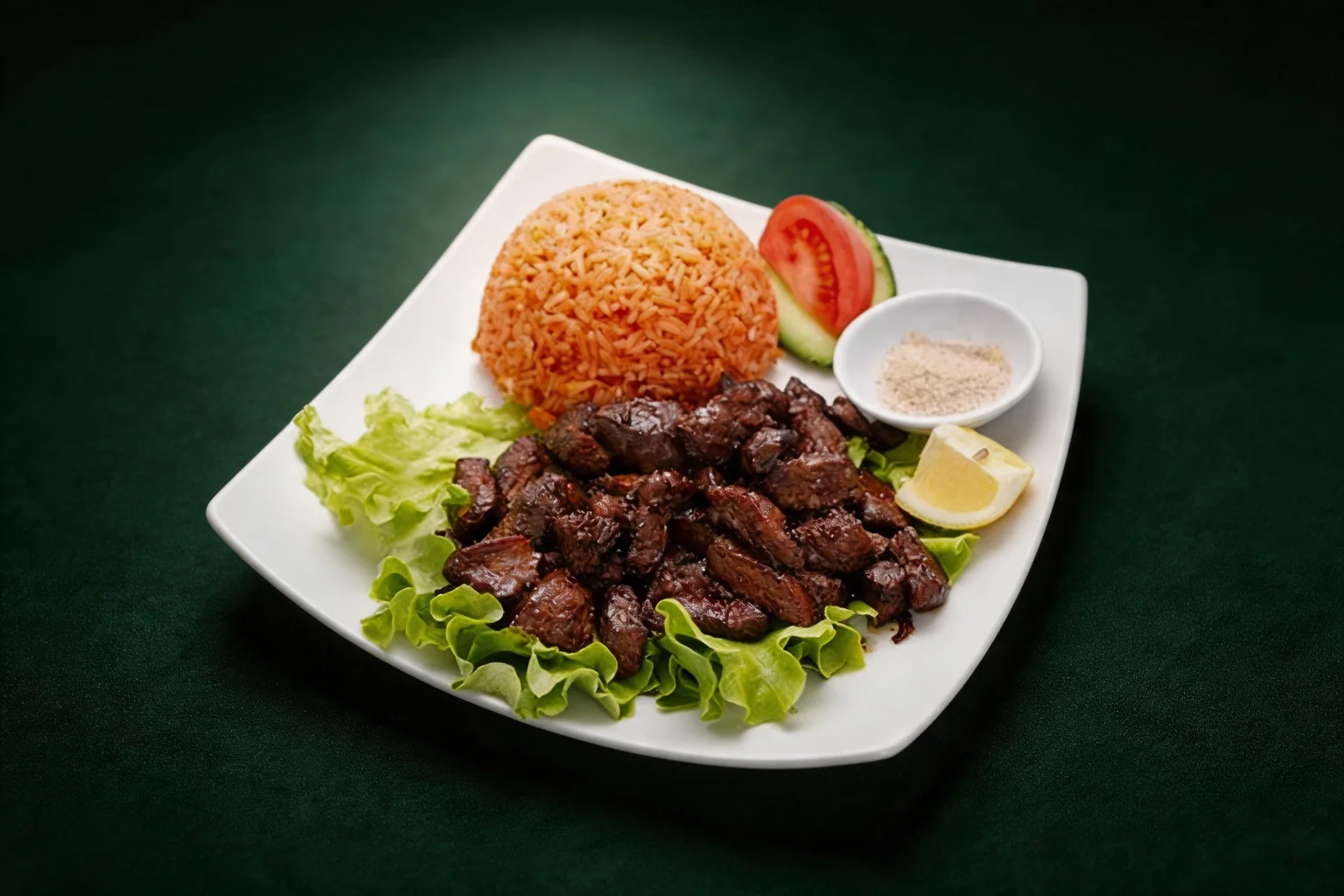 Loc Lac beef rice on a white plate, lettuce, tomato and lemon, dark green background